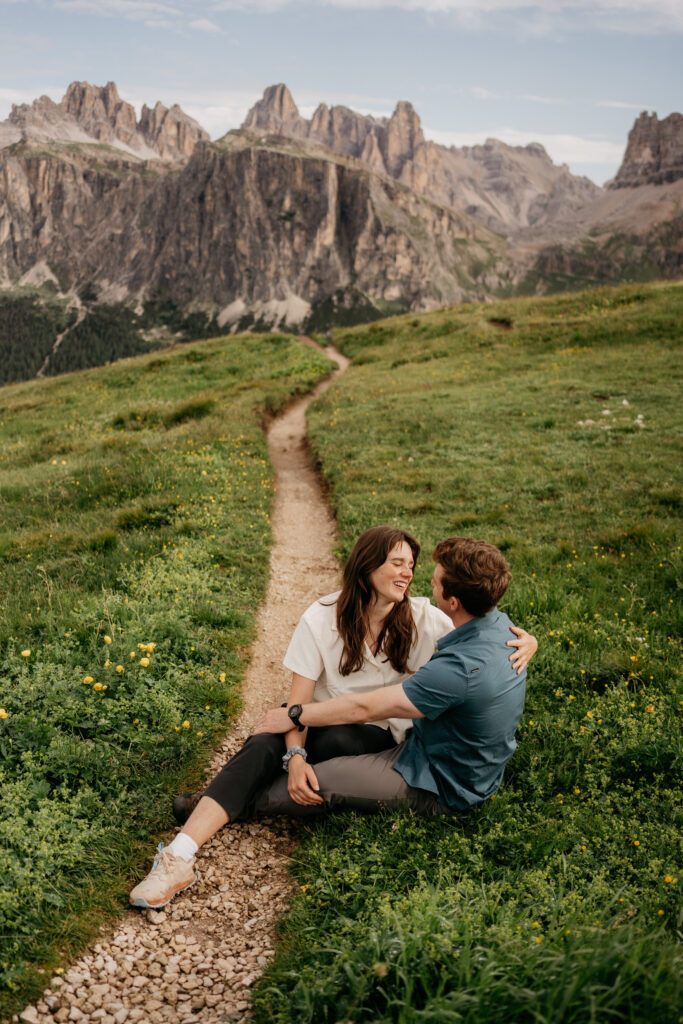 Couple sitting on grassy path in mountains