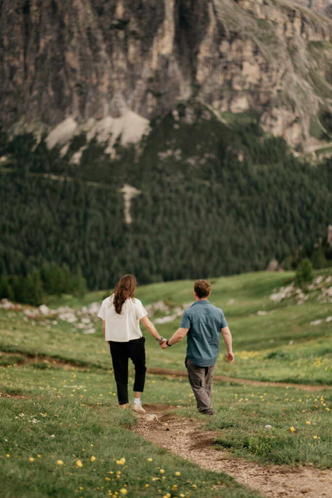 Couple walking hand in hand on mountain trail