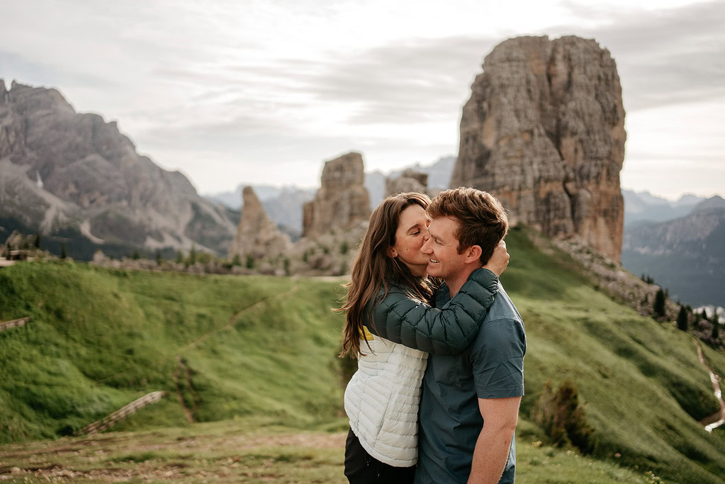 Couple embracing in scenic mountain landscape.