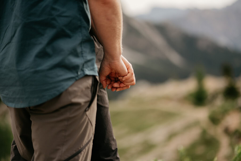 Couple holding hands outdoors in nature.