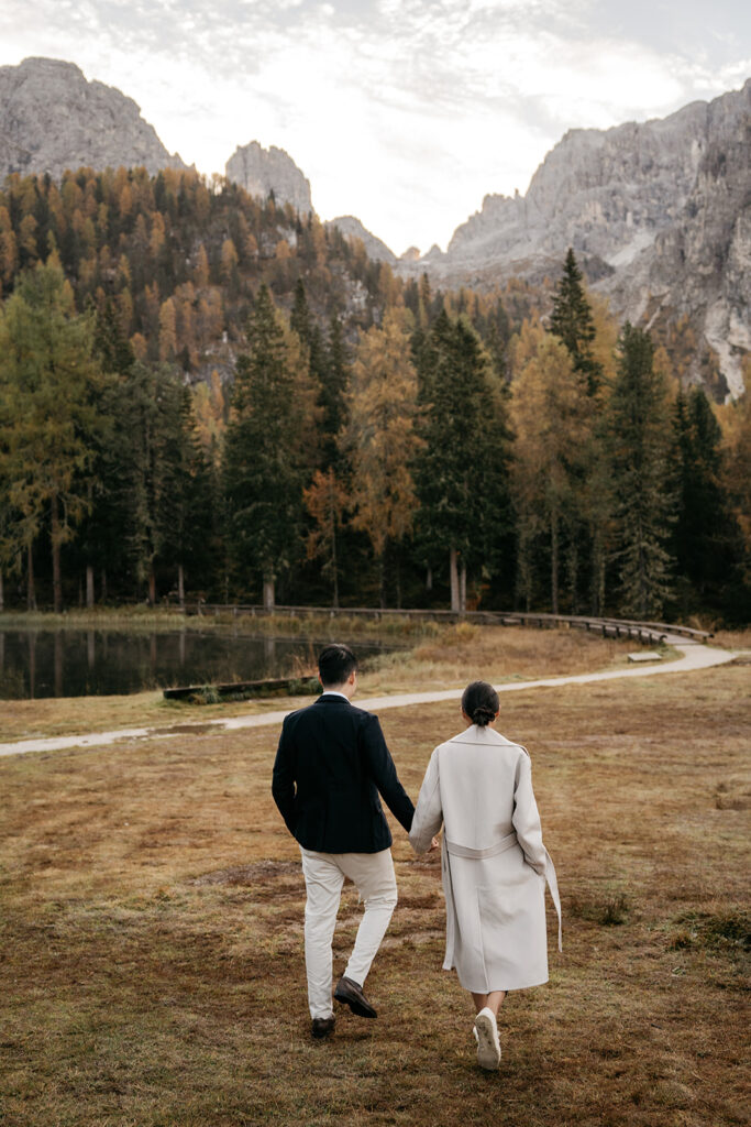 Couple walking in forested mountain landscape.