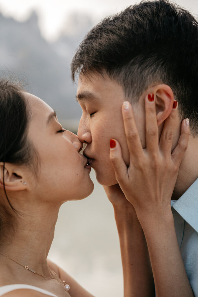 Couple sharing a tender kiss outdoors.