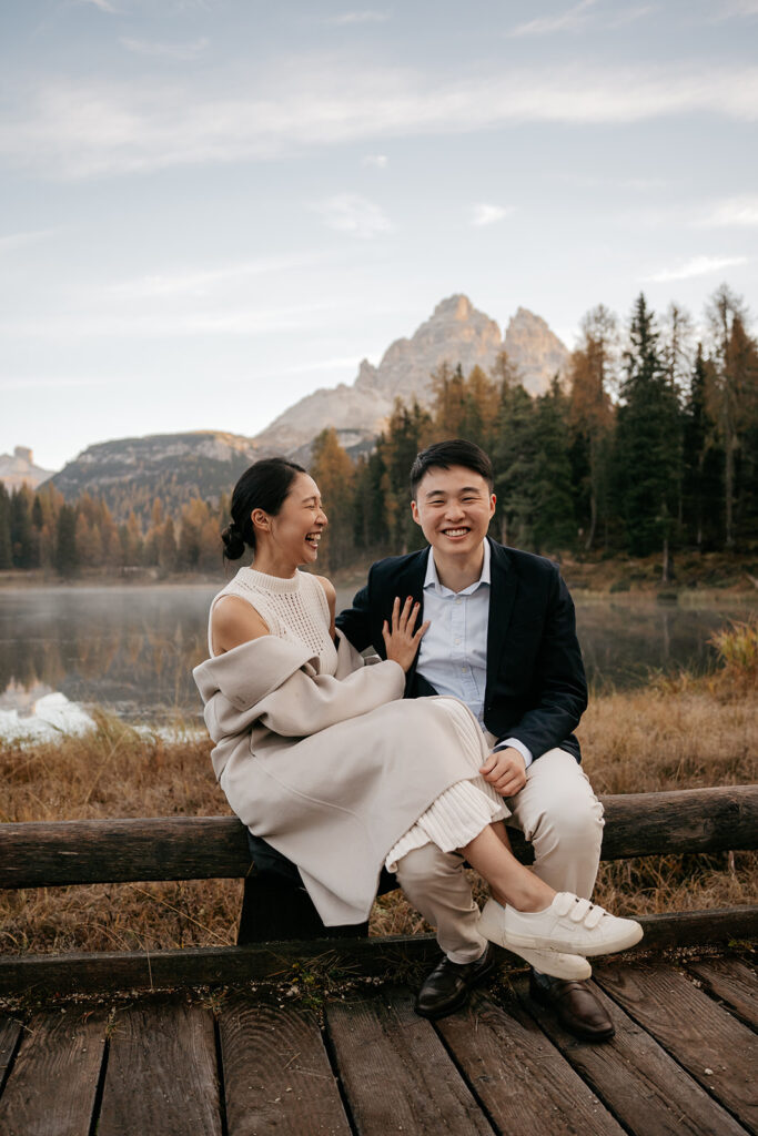 Couple smiling by a scenic mountain lake.