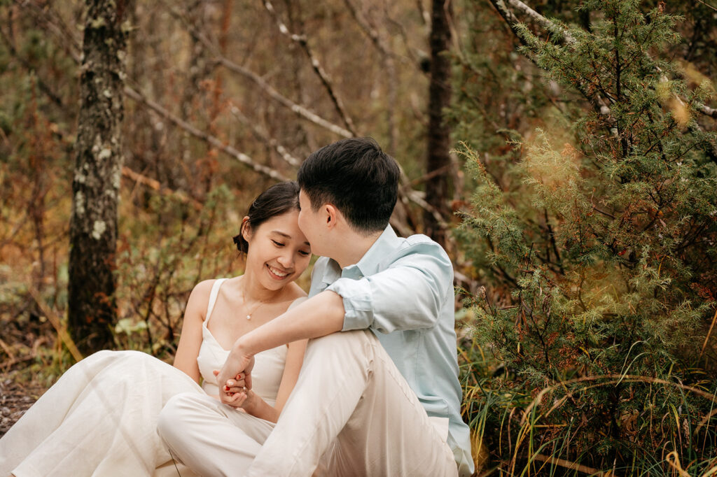 Couple sitting together in a forest setting.