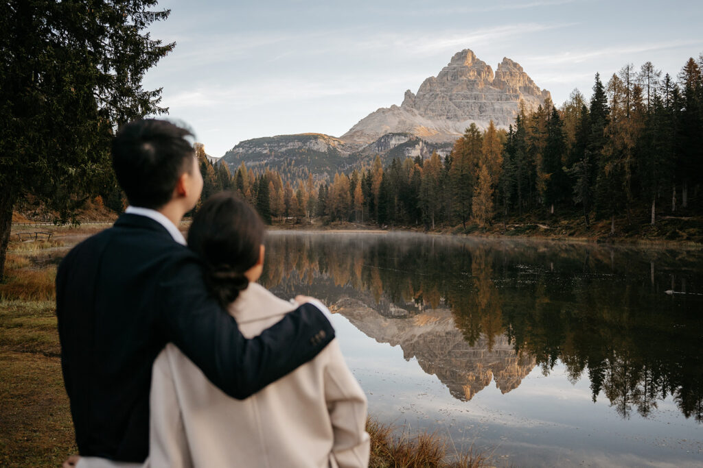 Couple enjoying mountain lake view at sunset.