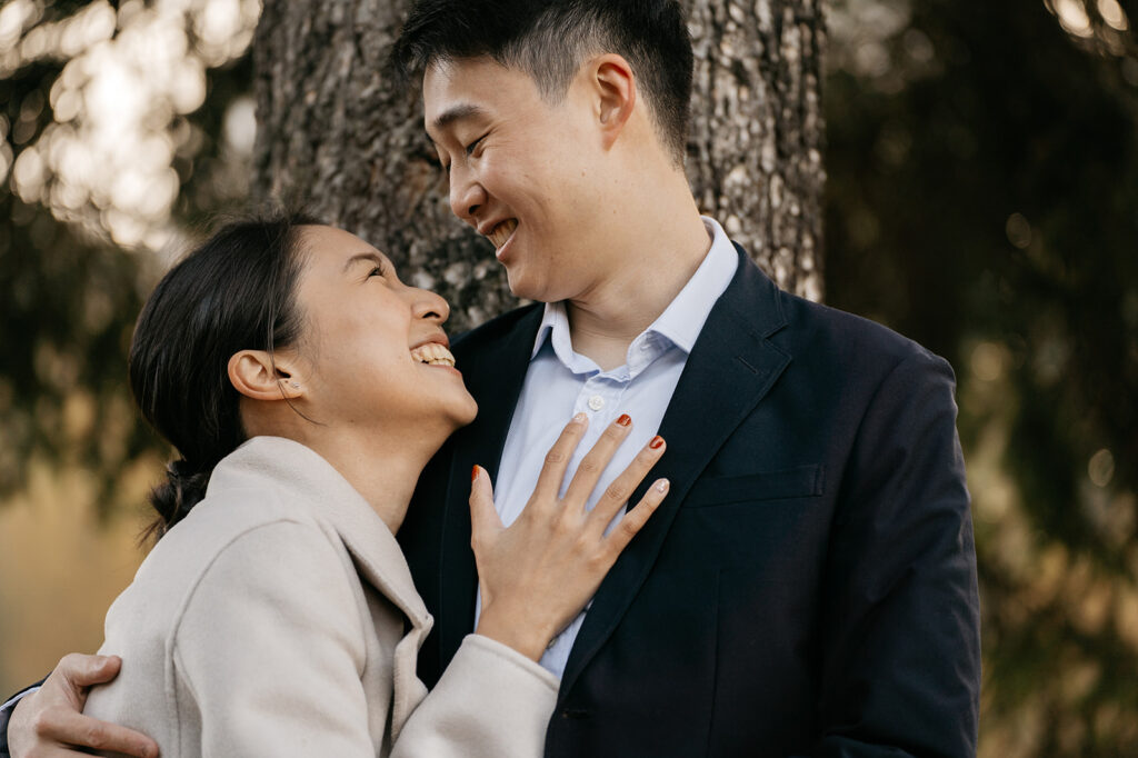 Smiling couple embracing outdoors by tree