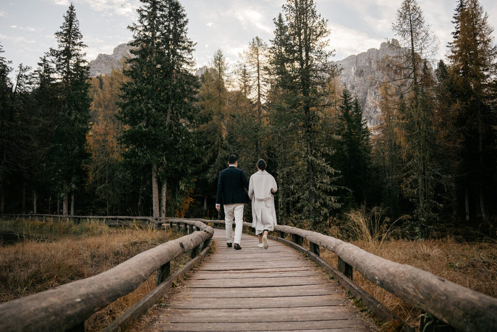 Couple walking on wooden path in forest