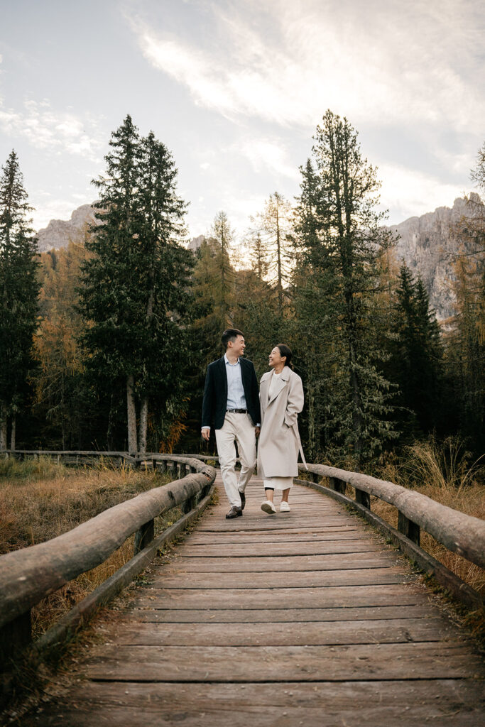 Couple walking on forest boardwalk during autumn