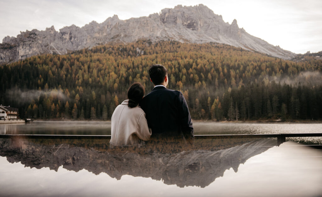 Couple embracing lakeside with mountain view