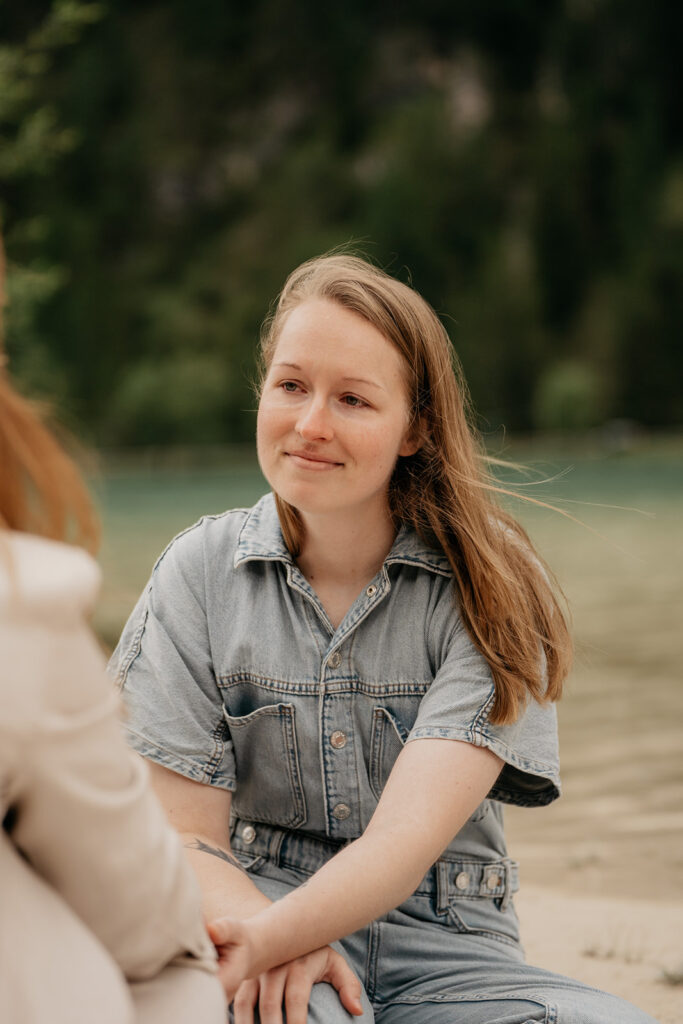 Smiling person in denim near a lake