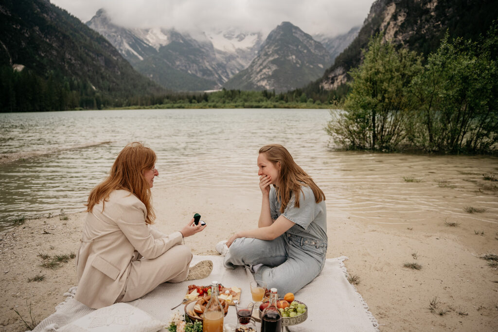 Couple having a picnic by a serene lake.