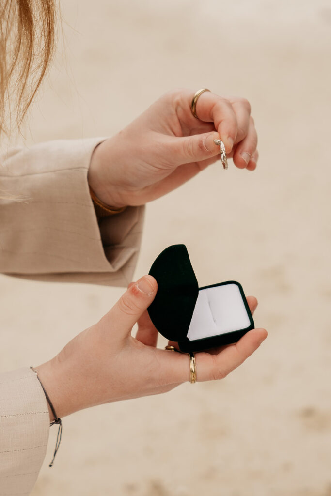 Person holding an engagement ring in box.