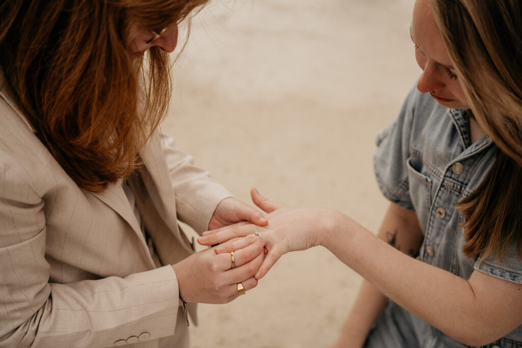 Person examines another's palm outdoors.