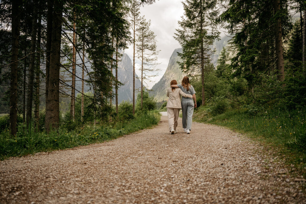 Two people walking on forest trail together.