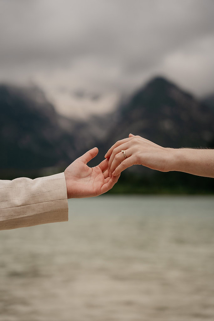 Hands reaching with a mountain background.