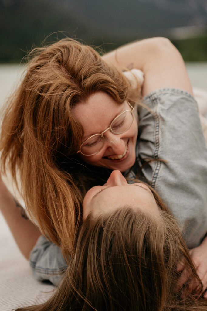 Two people smiling and laughing together outside.