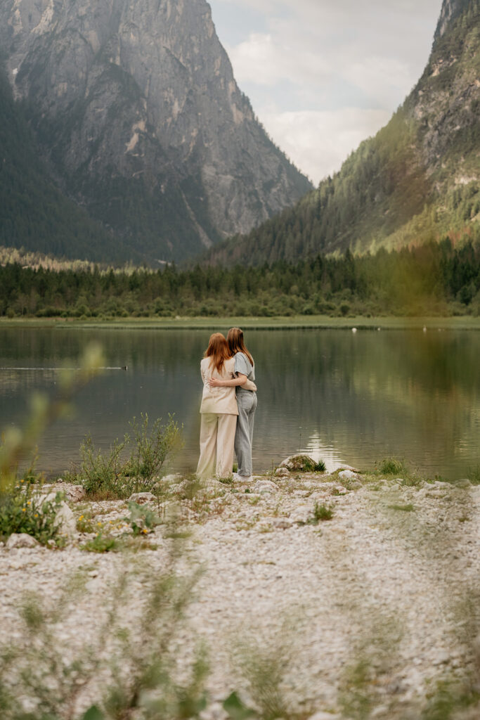 Couple embracing by a mountain lake view.