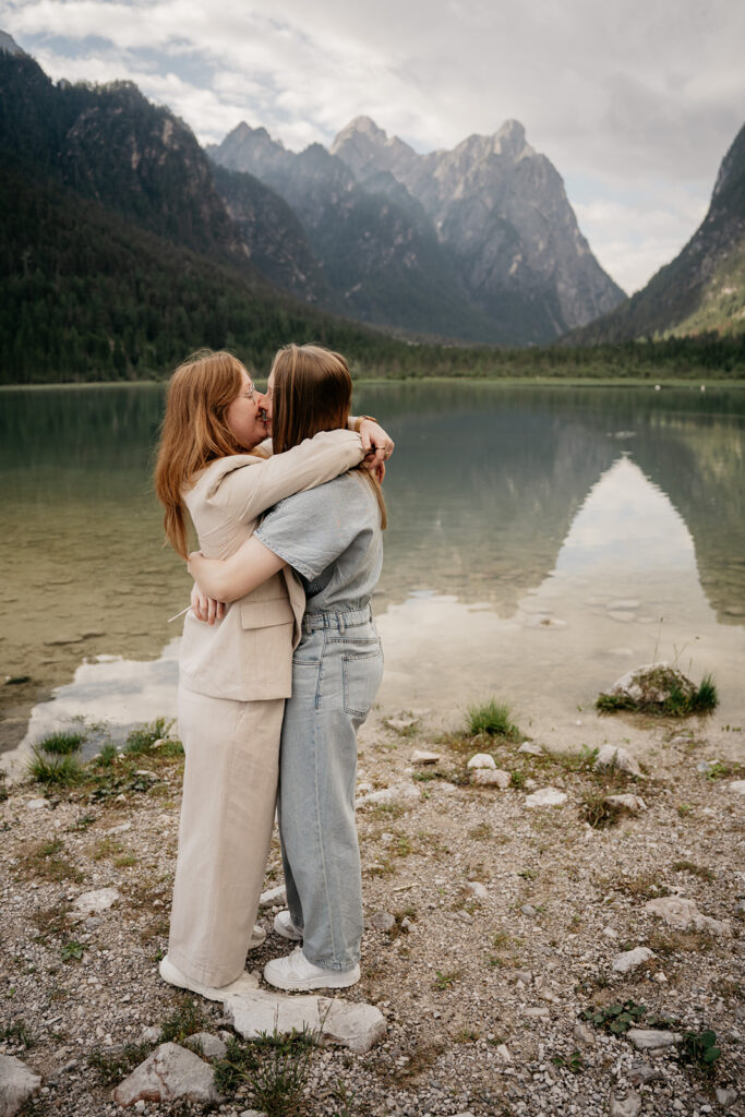 Couple embracing by a serene mountain lake.