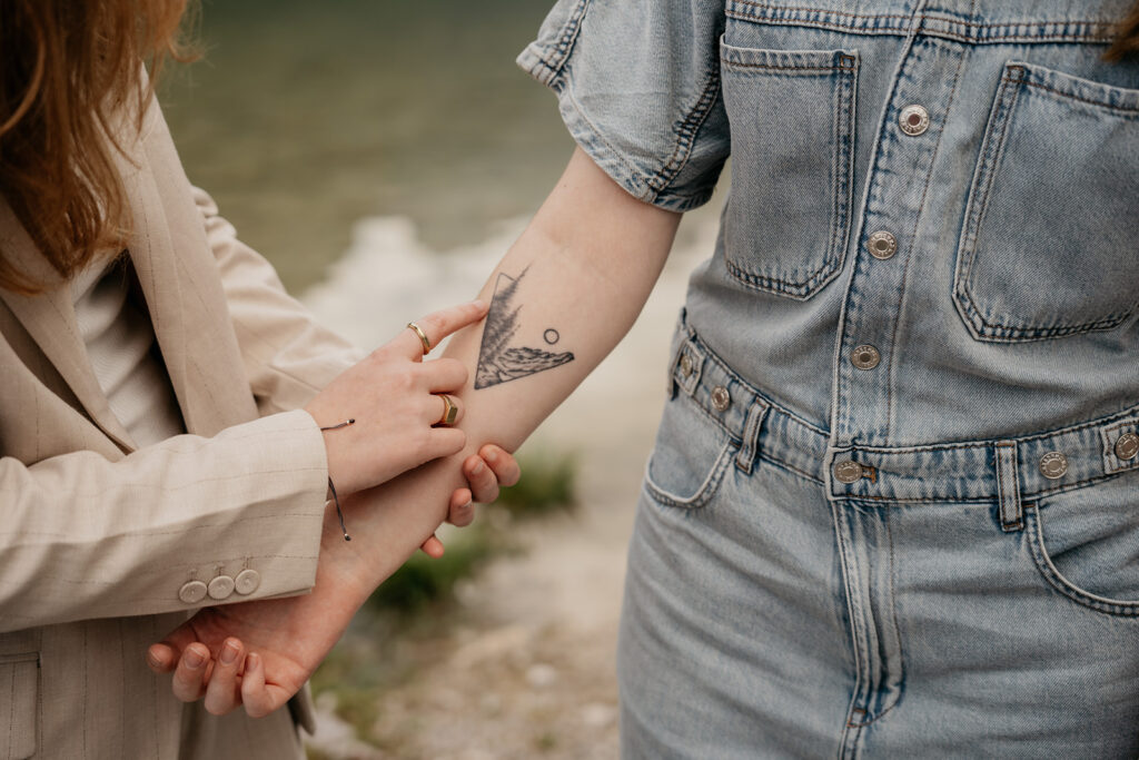 Two people showing arm tattoo.