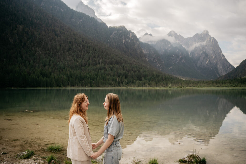 Couple holding hands by scenic mountain lake