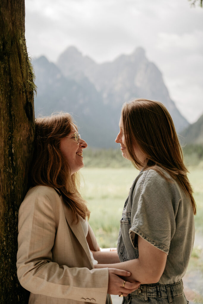 Two people smiling in a scenic mountain setting.