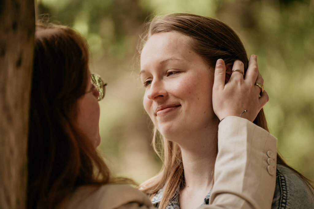 Two people smiling affectionately outdoors.