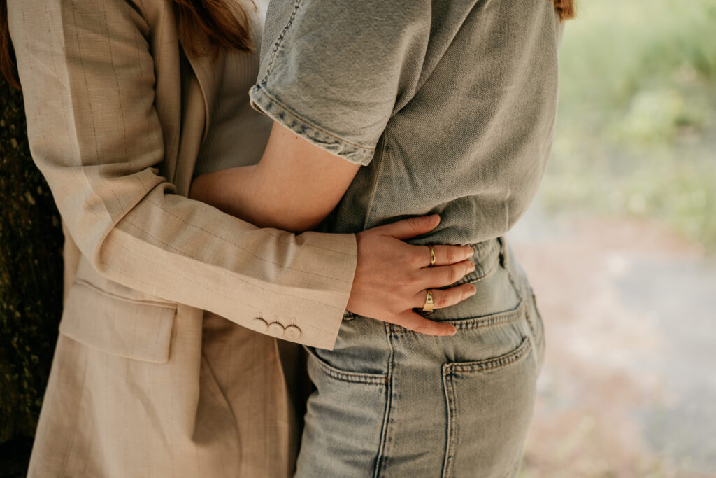 Couple embracing outdoors in casual outfits.