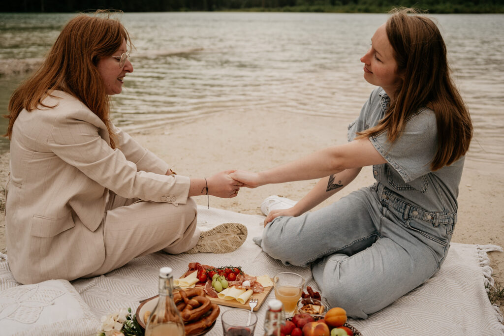 Two people enjoying picnic by the lake.