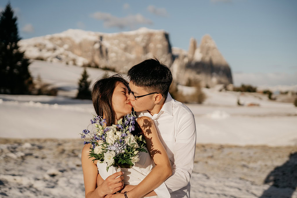 Couple kissing in snowy mountain landscape