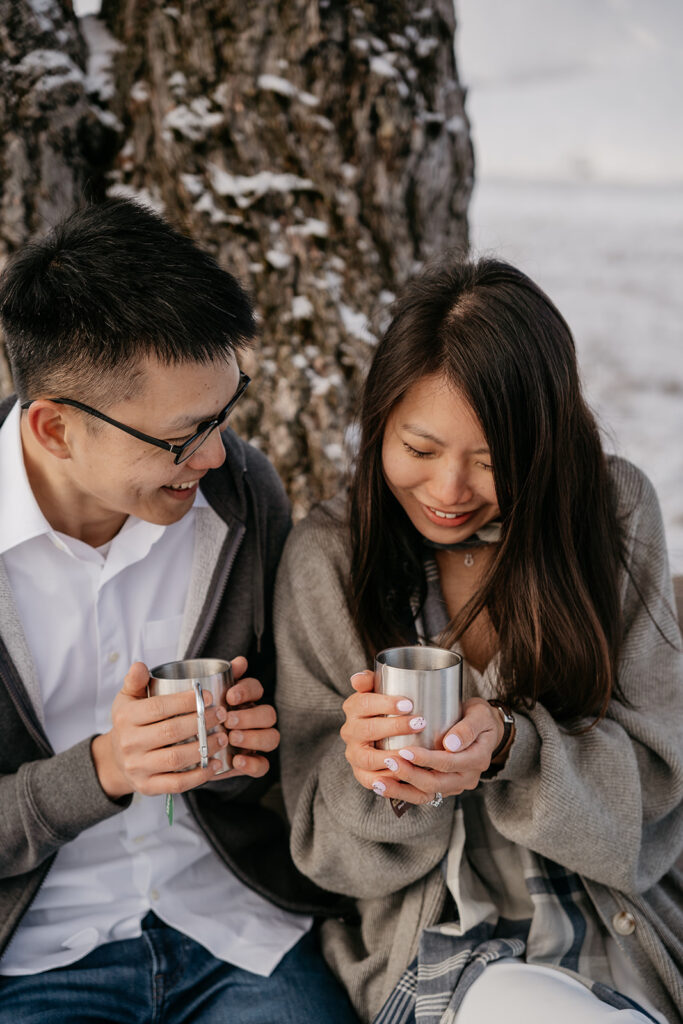 Couple enjoying hot drinks in snowy landscape