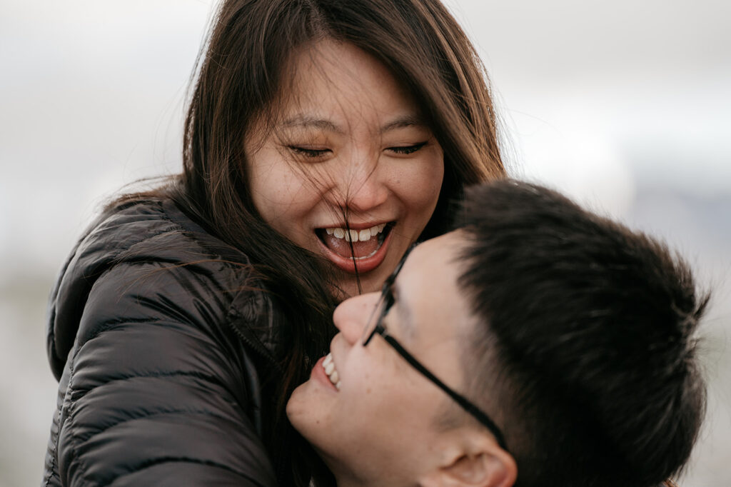 Smiling couple embracing joyfully outdoors.