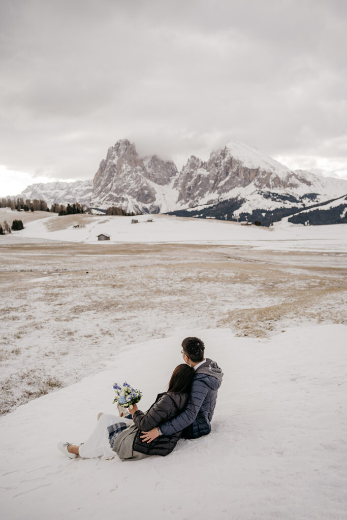 Couple enjoying snowy mountain landscape view.