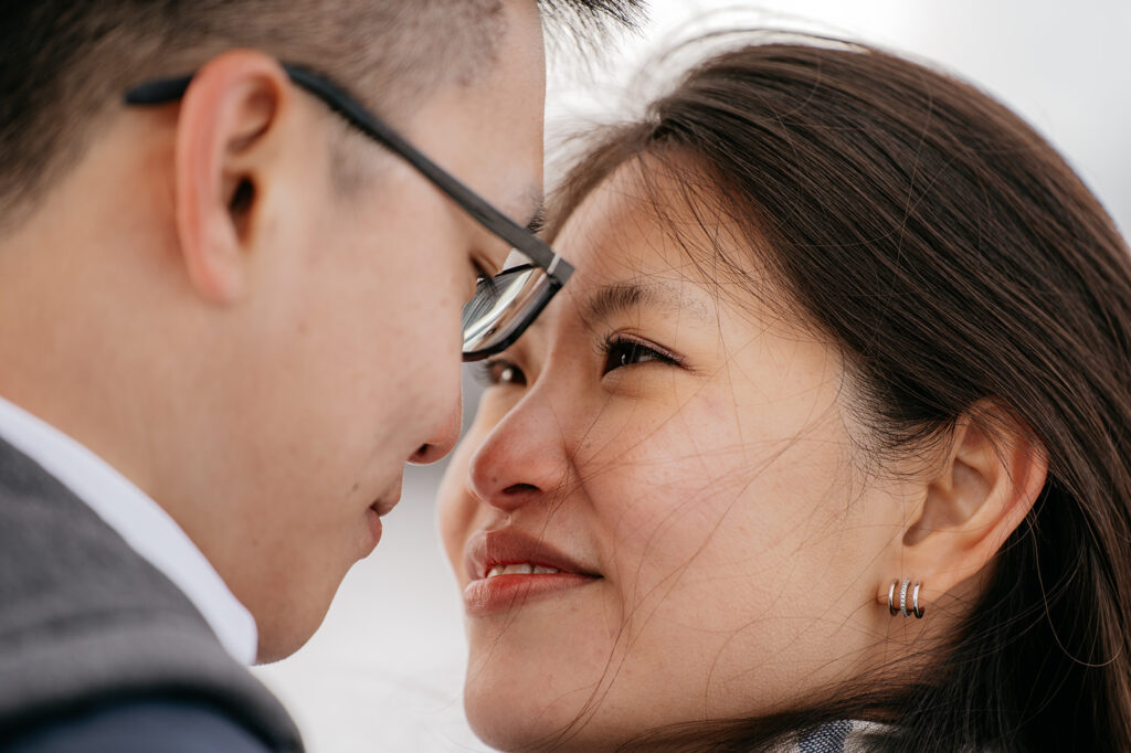 Close-up of a smiling couple looking at each other.