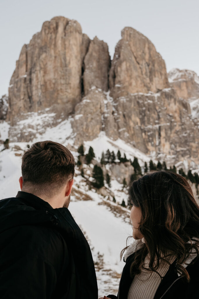 Couple admiring snowy mountain landscape.