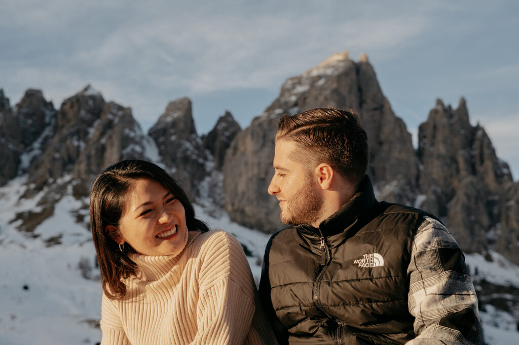 Couple smiling in snowy mountain landscape