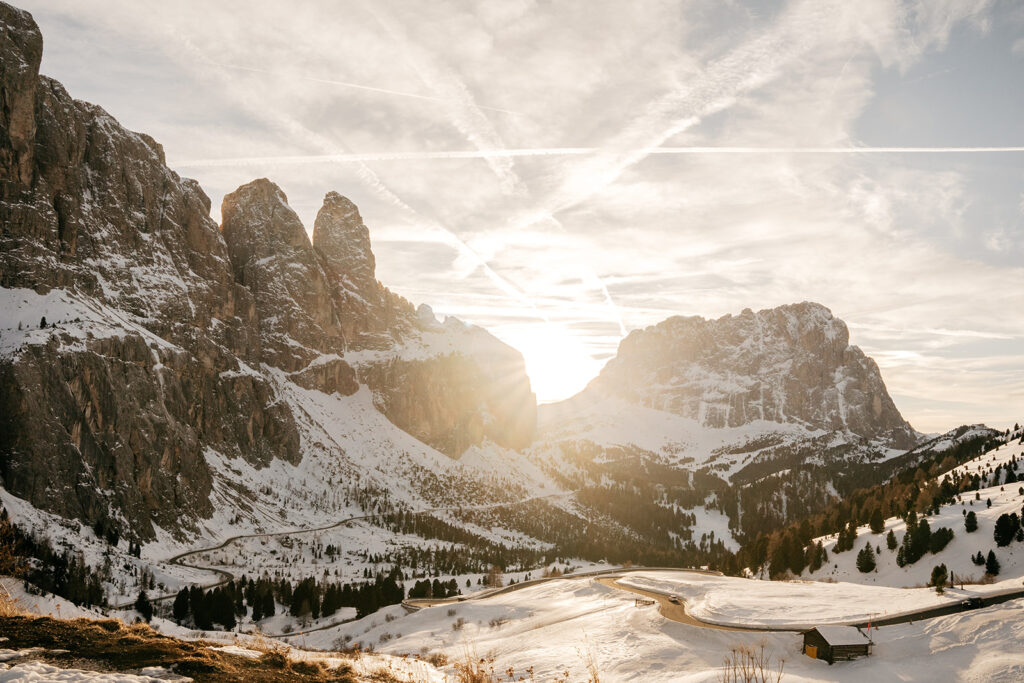 Sunrise over snowy mountain peaks and valley road.