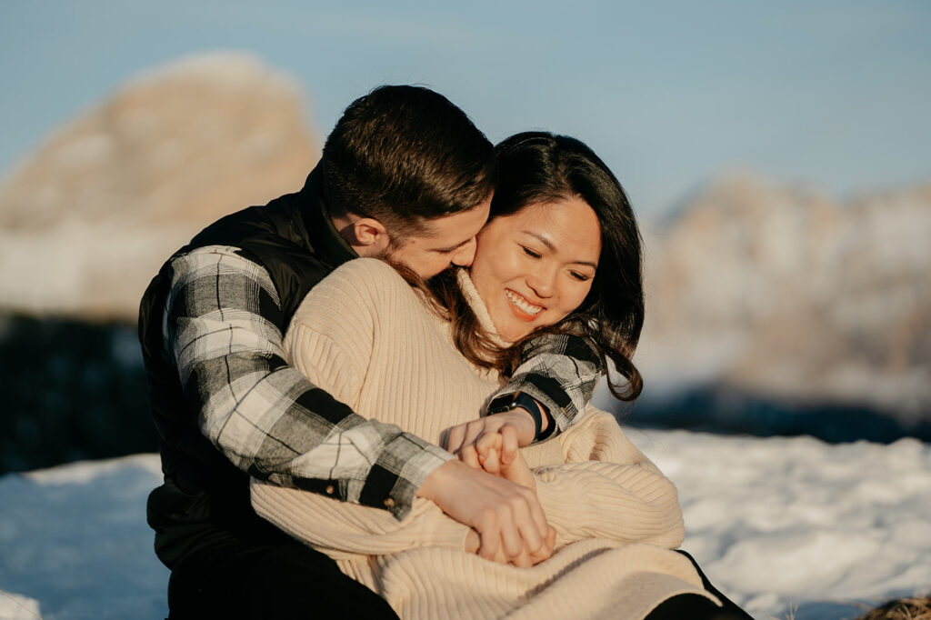 Couple cuddling in snowy mountains