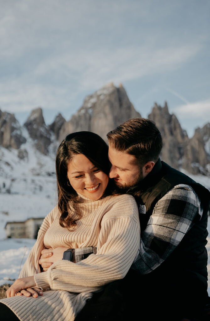 Couple embracing with snowy mountains background.