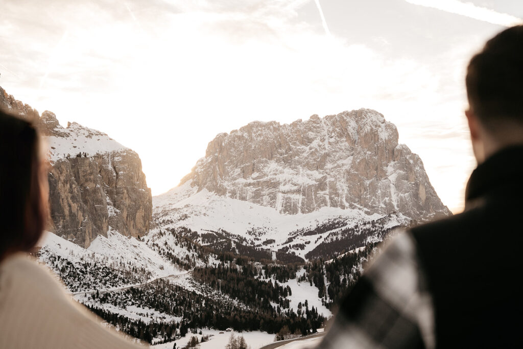 People admire snow-covered mountain landscape at sunset.