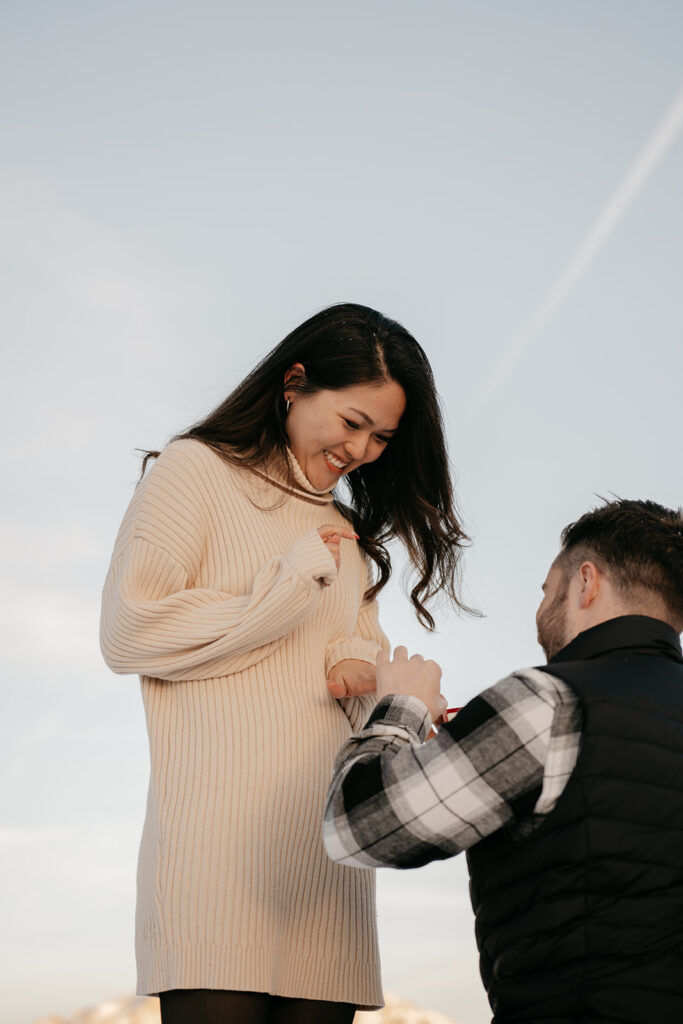 Man proposing to woman outdoors, smiling