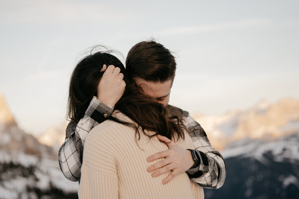 Couple embracing with snowy mountains background.