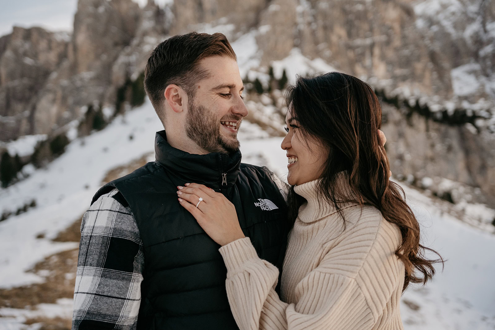 Couple smiling in snowy mountain landscape