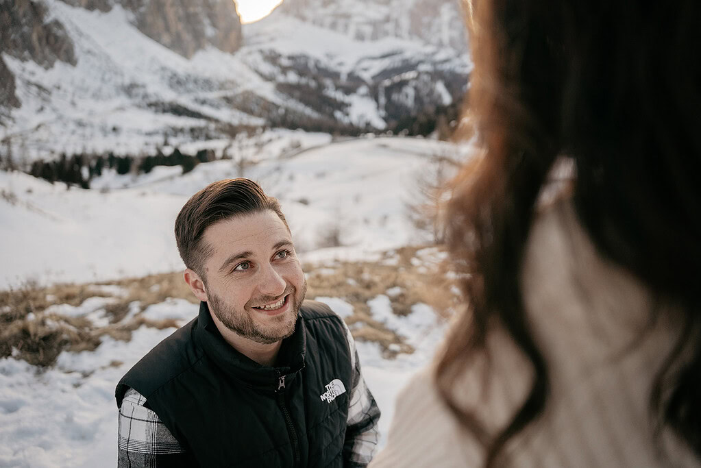 Man smiling in snowy mountain landscape proposal