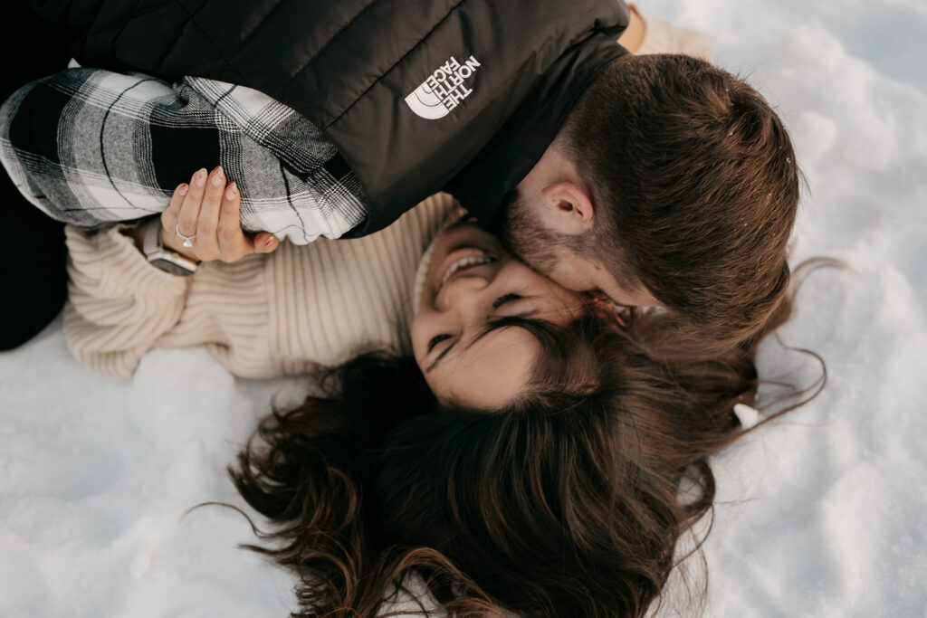 Couple smiling and cuddling on snow