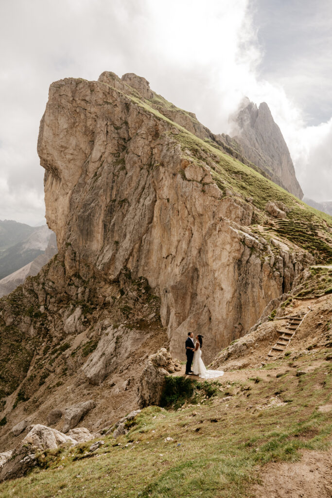 Bride and groom on mountain cliff