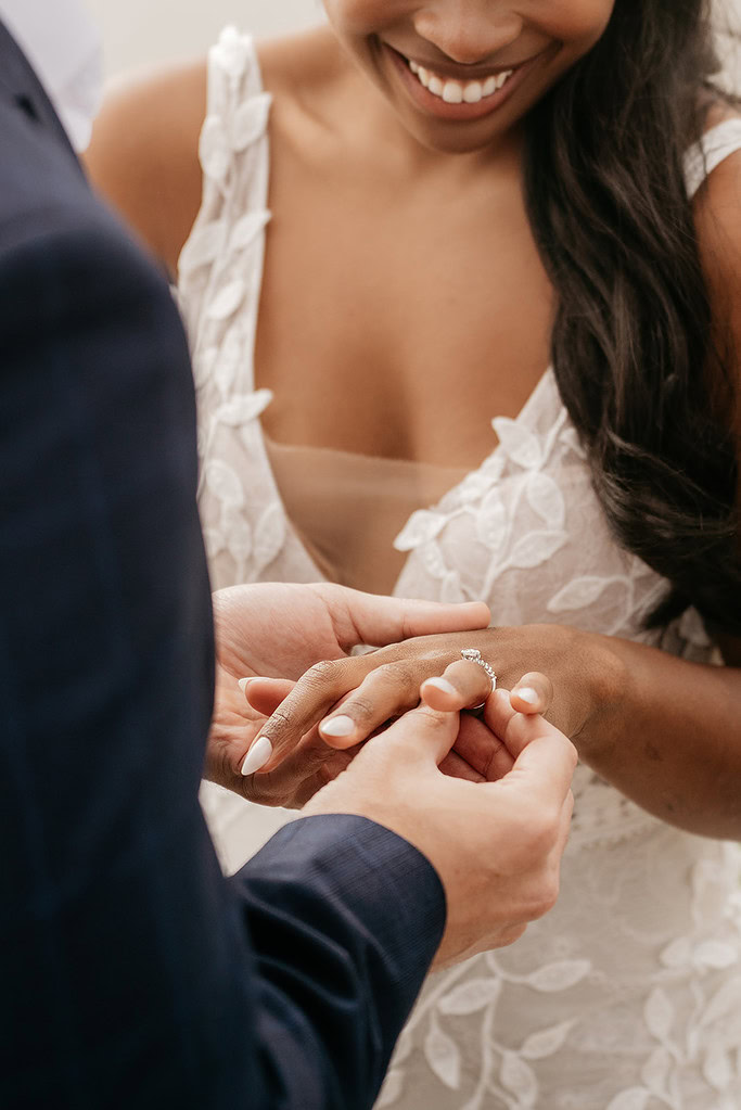 Couple exchanging rings during wedding ceremony.