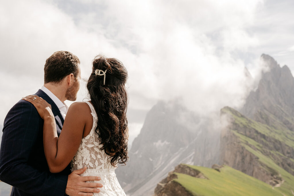 Couple embracing with mountain view in background.