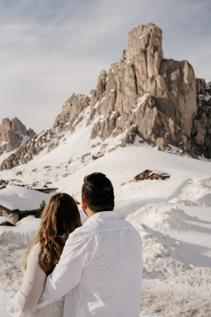 Couple admiring snow-covered mountain landscape.