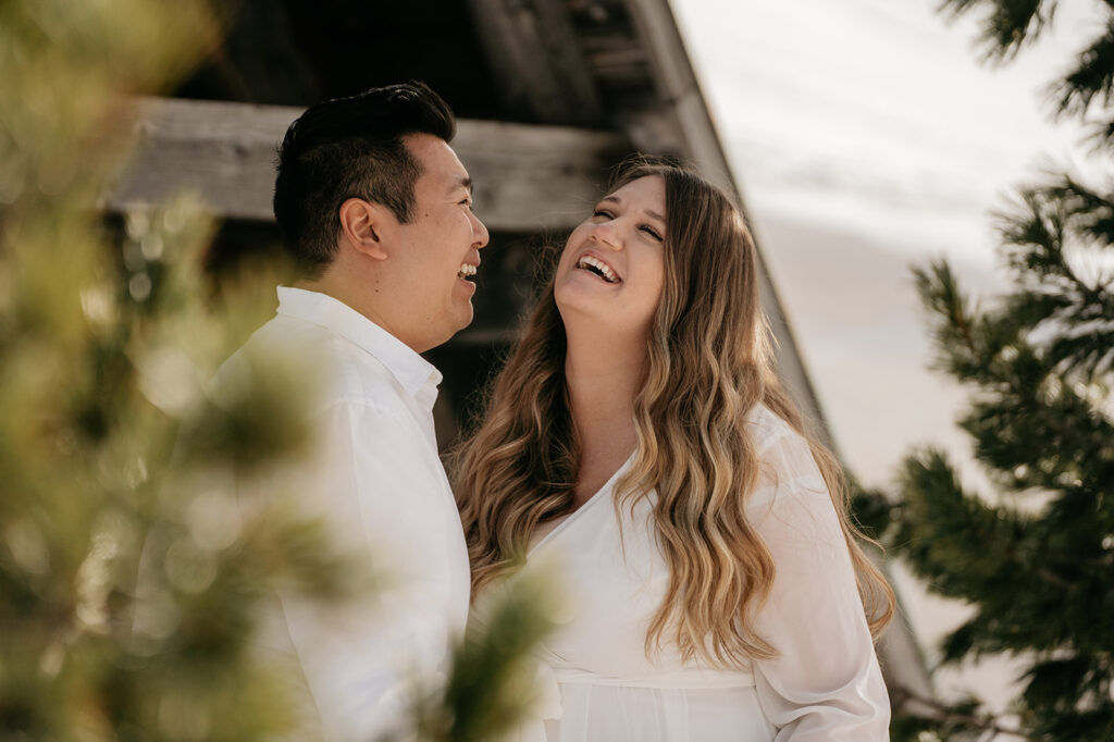 Smiling couple outside near trees.