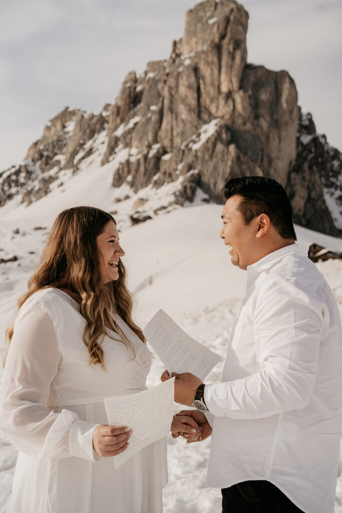 Couple exchanging vows in snowy mountain setting.